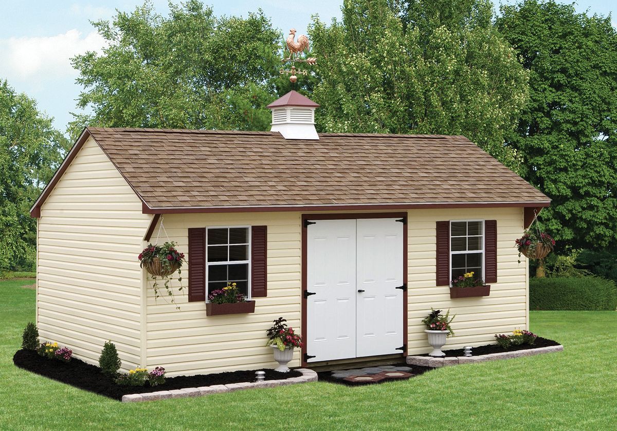a small house with a brown roof is sitting in the middle of a lush green field .