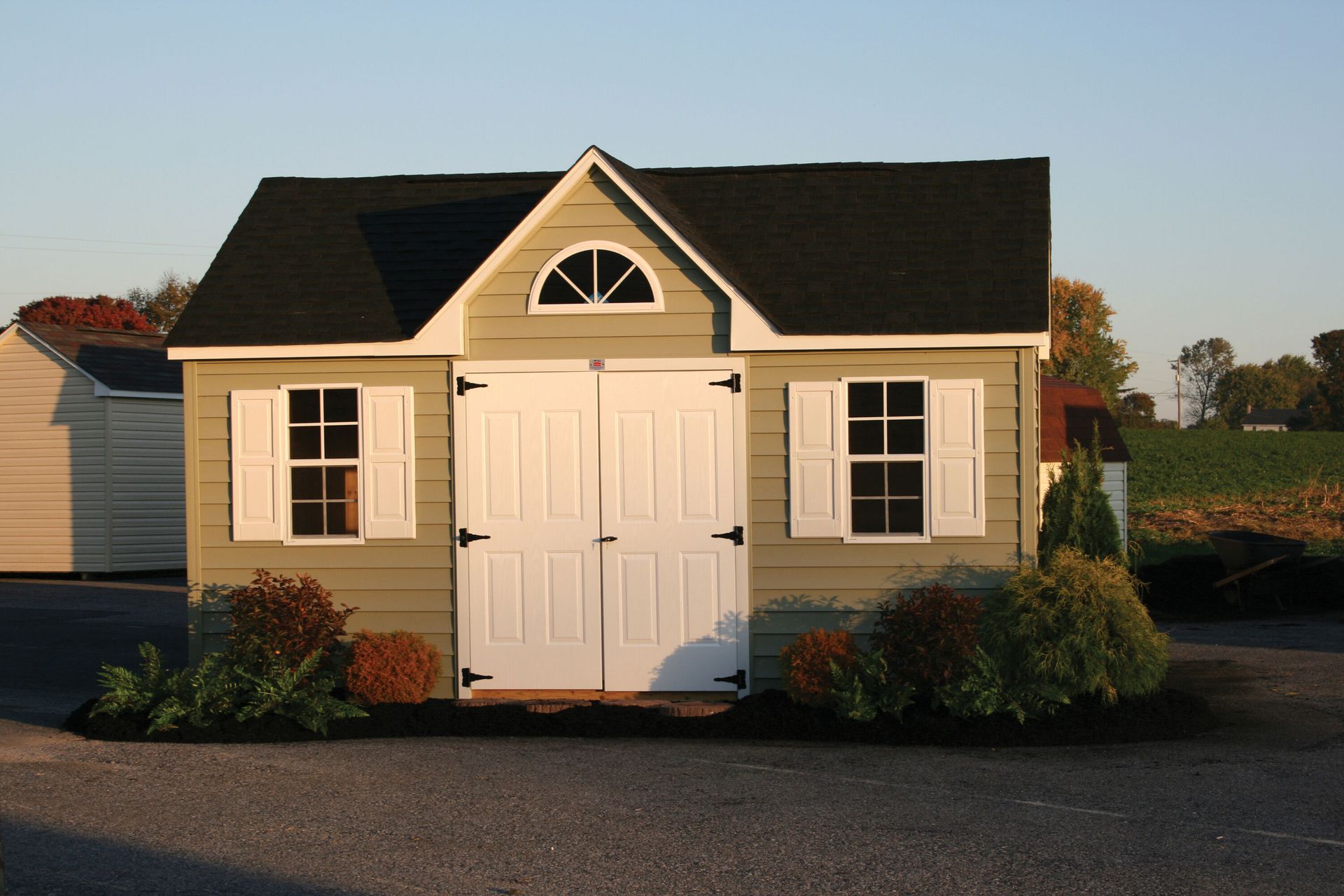 a small house with a black roof and white shutters