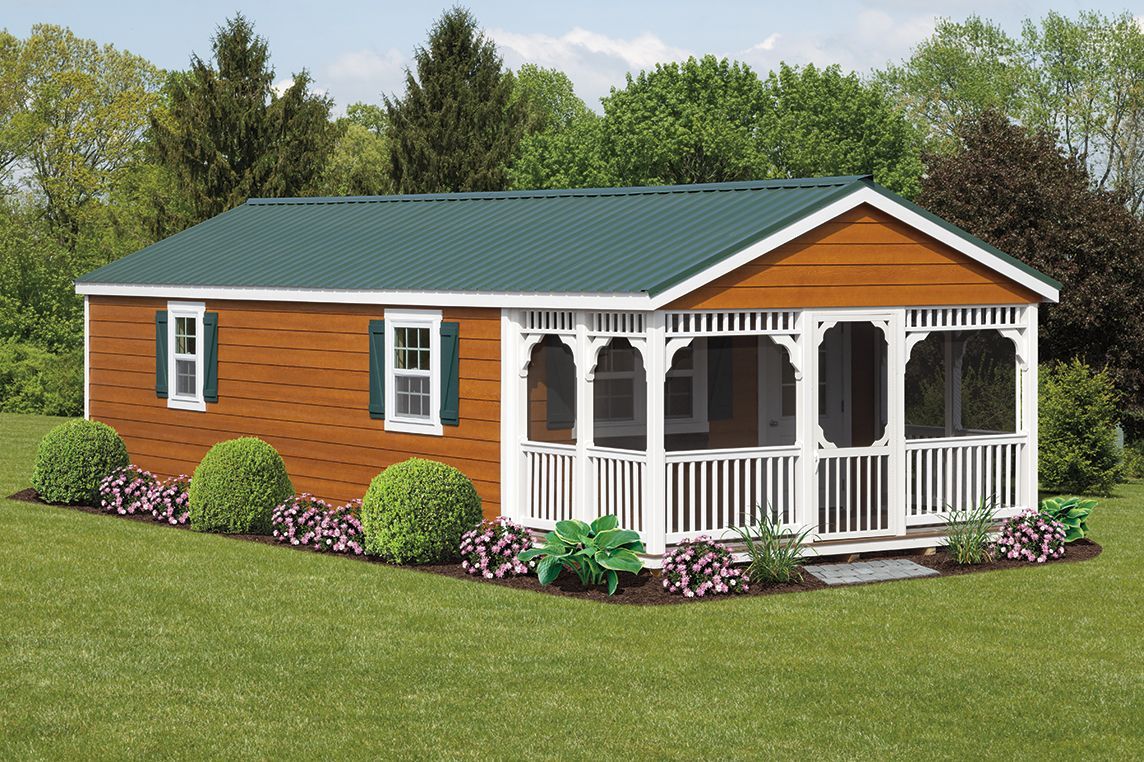 a small house with a screened in porch and a green roof