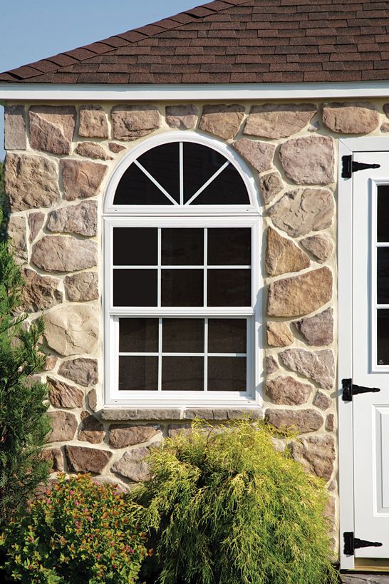 a stone building with a white window and a white door