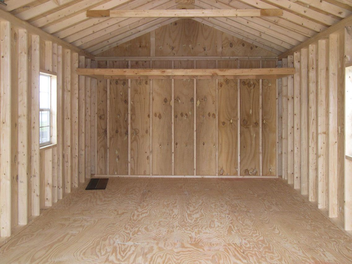 an empty shed with wooden walls and a roof