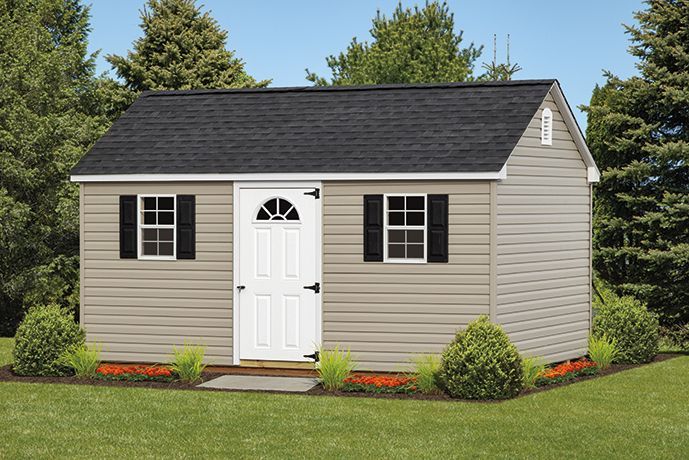 a small shed with a black roof and white shutters