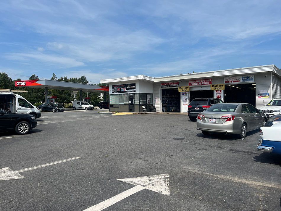 A parking lot with cars parked in front of a gas station.