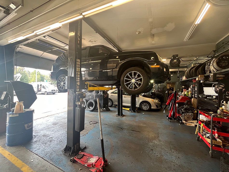 A car is sitting on a lift in a garage.