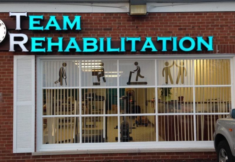 A brick building with a sign that says team rehabilitation