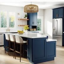 Modern kitchen with navy blue island and cabinets, wood countertops, and white walls.