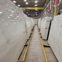 Large slabs of white marble stacked in an industrial warehouse.