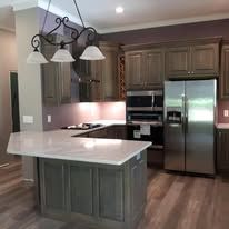 Kitchen with a large island, stainless steel appliances, and dark wood cabinets.
