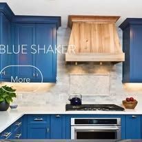 Blue shaker kitchen with wood hood and appliances.