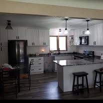 Kitchen with white cabinets, stainless steel appliances, and a dark-colored island.