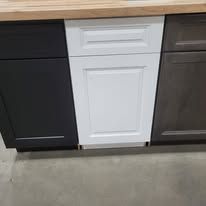 Three kitchen cabinet doors: black, white, and gray.