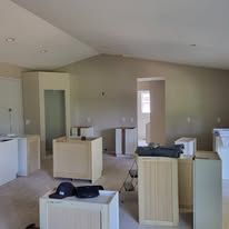 Empty room under construction with cabinets, doorways and unfinished walls.