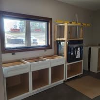 Kitchen cabinets under construction near a window with an outside view.