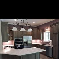 Kitchen with cabinets, stainless steel appliances, and a hanging light fixture.