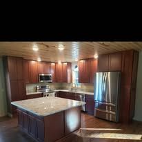 Modern kitchen with wooden cabinets, stainless steel appliances, and granite countertops.