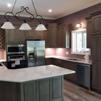 Kitchen with dark cabinets, light countertops, and a chandelier.