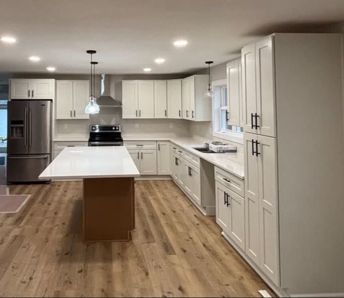 Newly renovated kitchen with white cabinets, island, and stainless steel appliances.