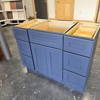 Blue bathroom vanity with drawers and cabinet doors.