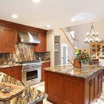 Spacious kitchen with wood cabinets, island, granite countertops, and stainless steel appliances.