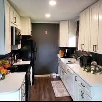 Kitchen with cabinets, appliances, and sink. Dark wall on the left, counter on the right.