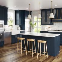 Kitchen with navy blue cabinets, white countertops, and three stools.