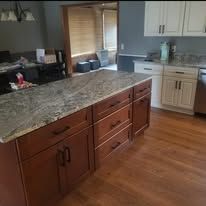 Dark brown kitchen cabinets and a gray countertop in a modern kitchen.