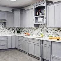 Gray kitchen cabinets and countertops with a backsplash.