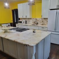 Kitchen with white cabinets, countertop, stove, and a yellow wall in the background.