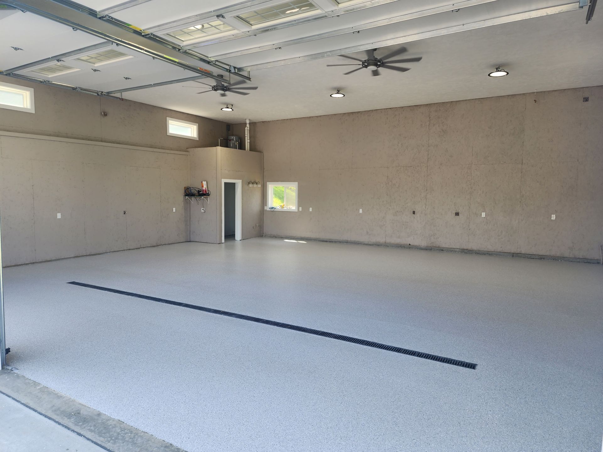 a large empty garage with a ceiling fan