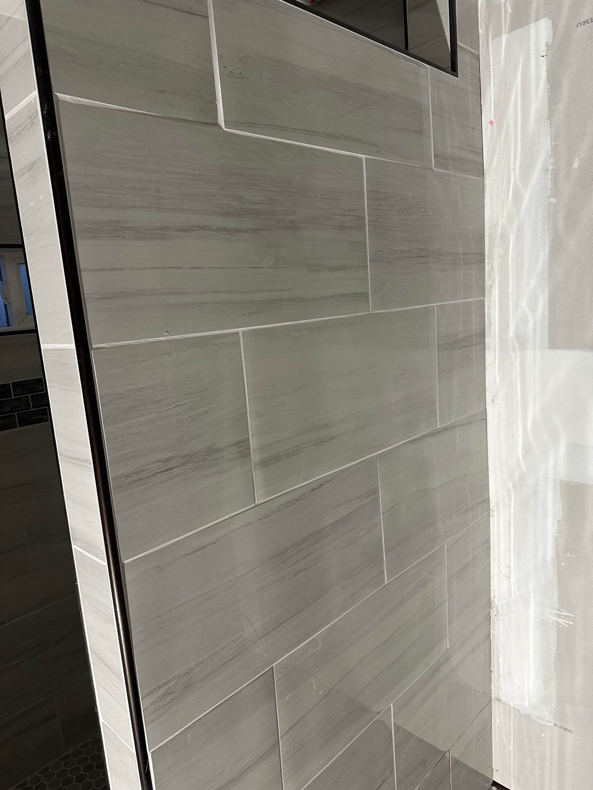 Gray tiled wall beside a white curtain in a modern interior
