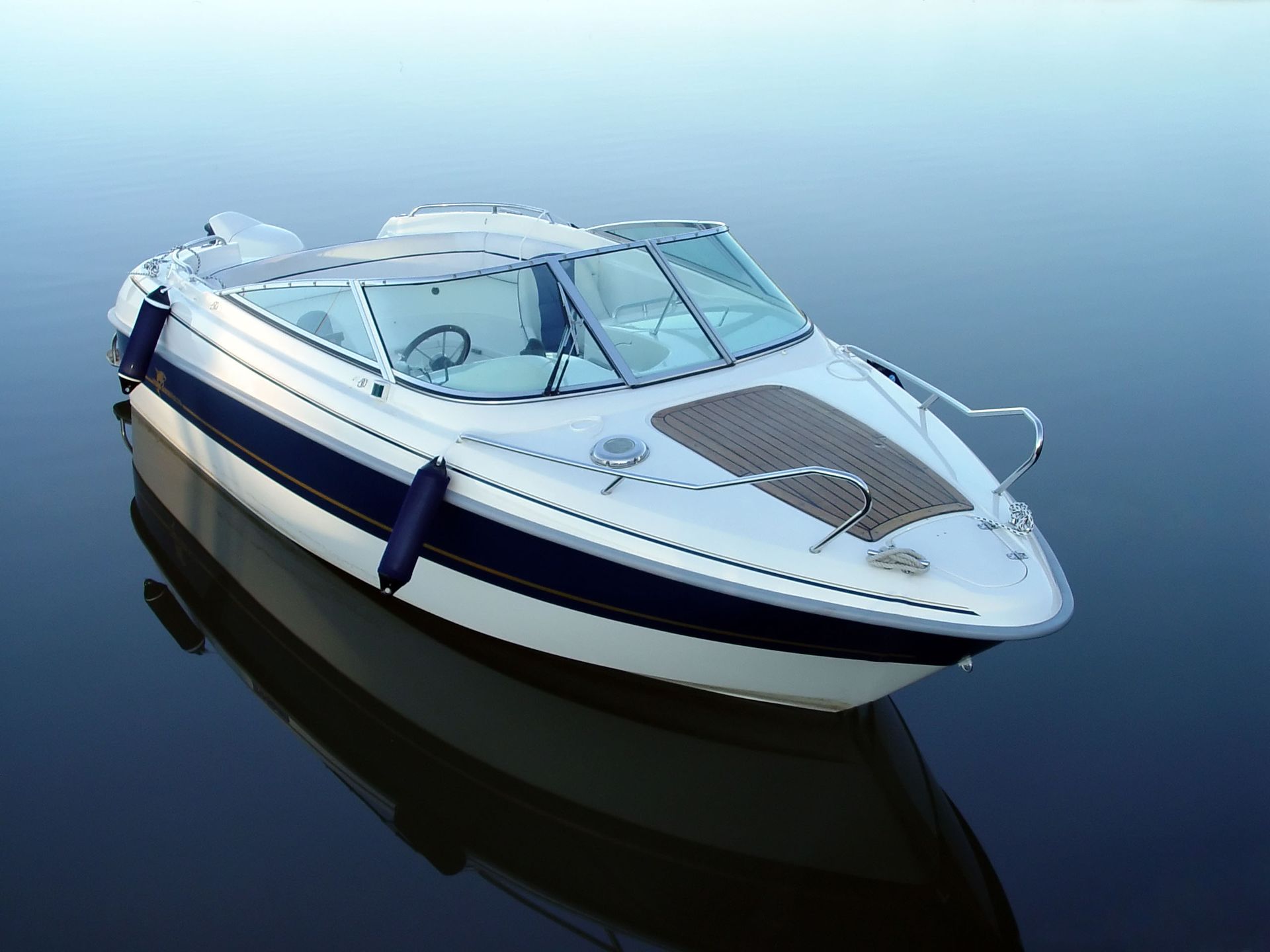 A white and blue boat is floating in the water.