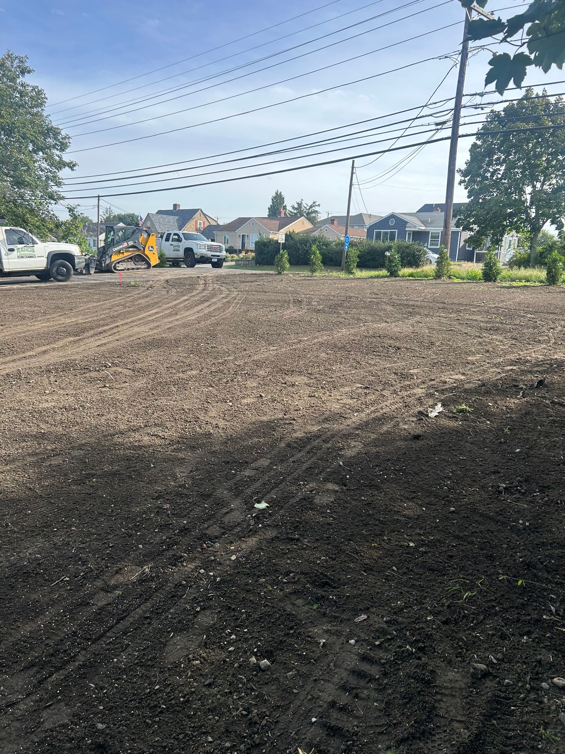 A white truck is parked in the middle of a dirt field.