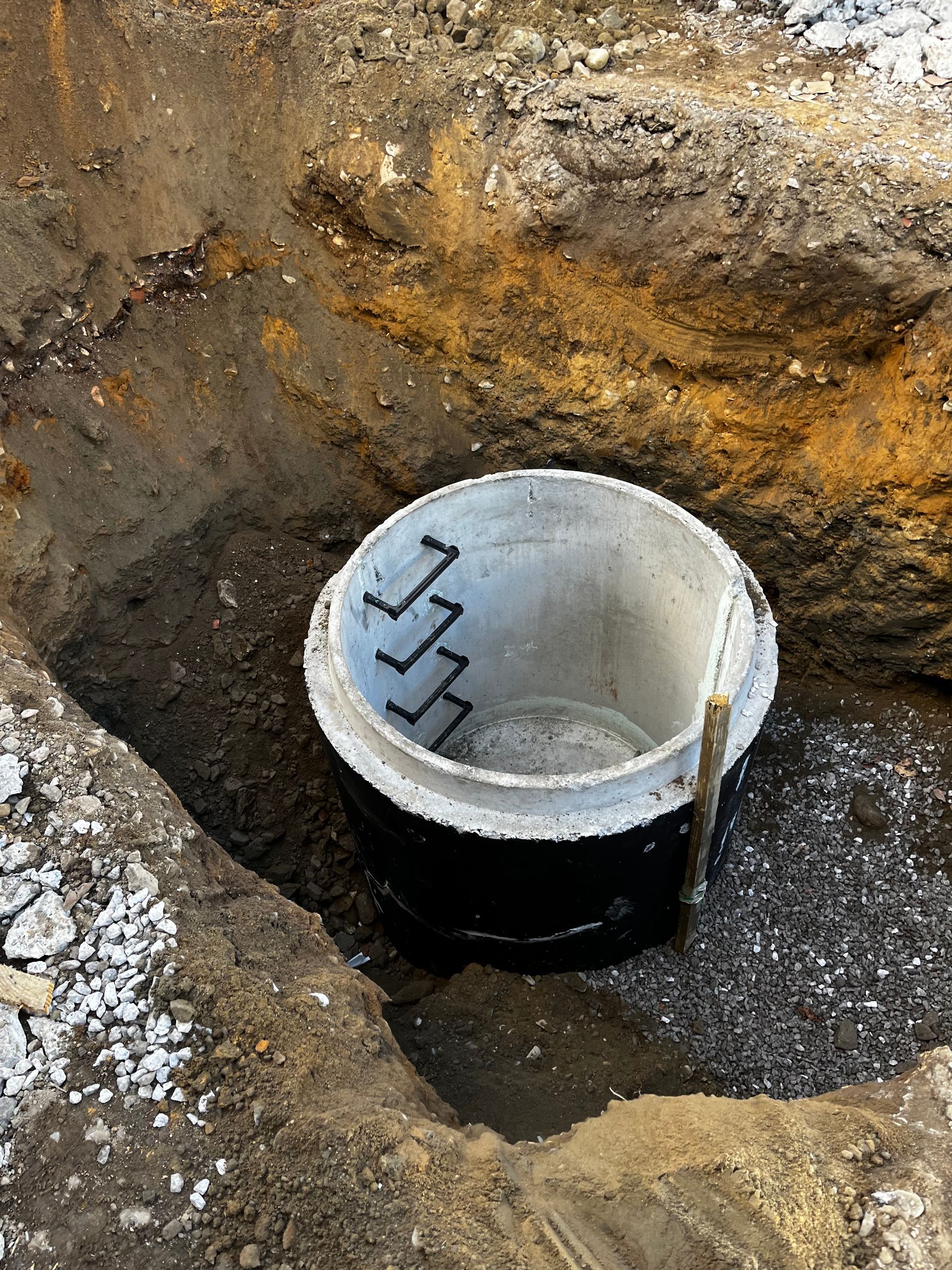 A concrete ring is sitting in the middle of a hole in the ground.