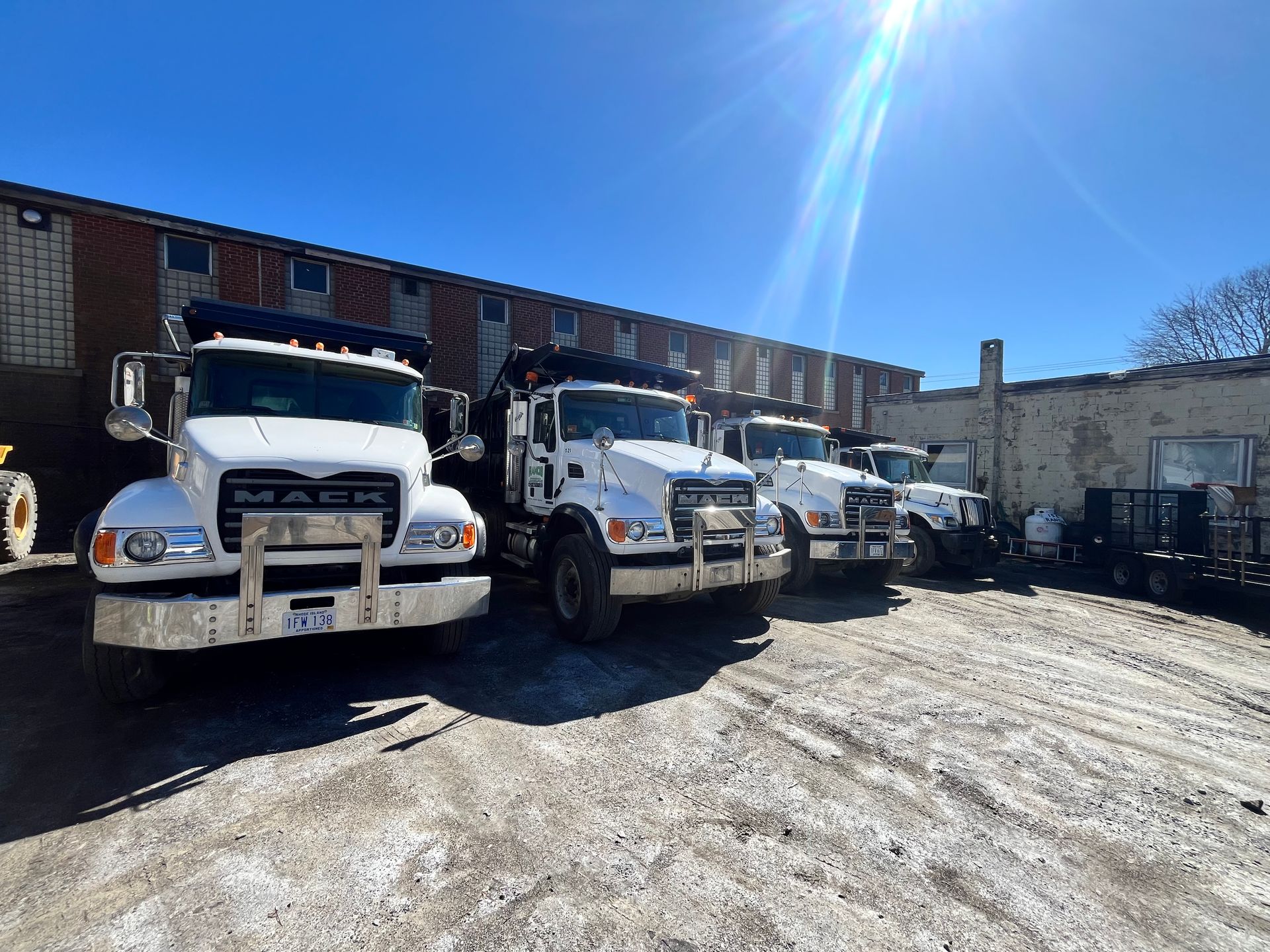 A row of dump trucks are parked in front of a building.