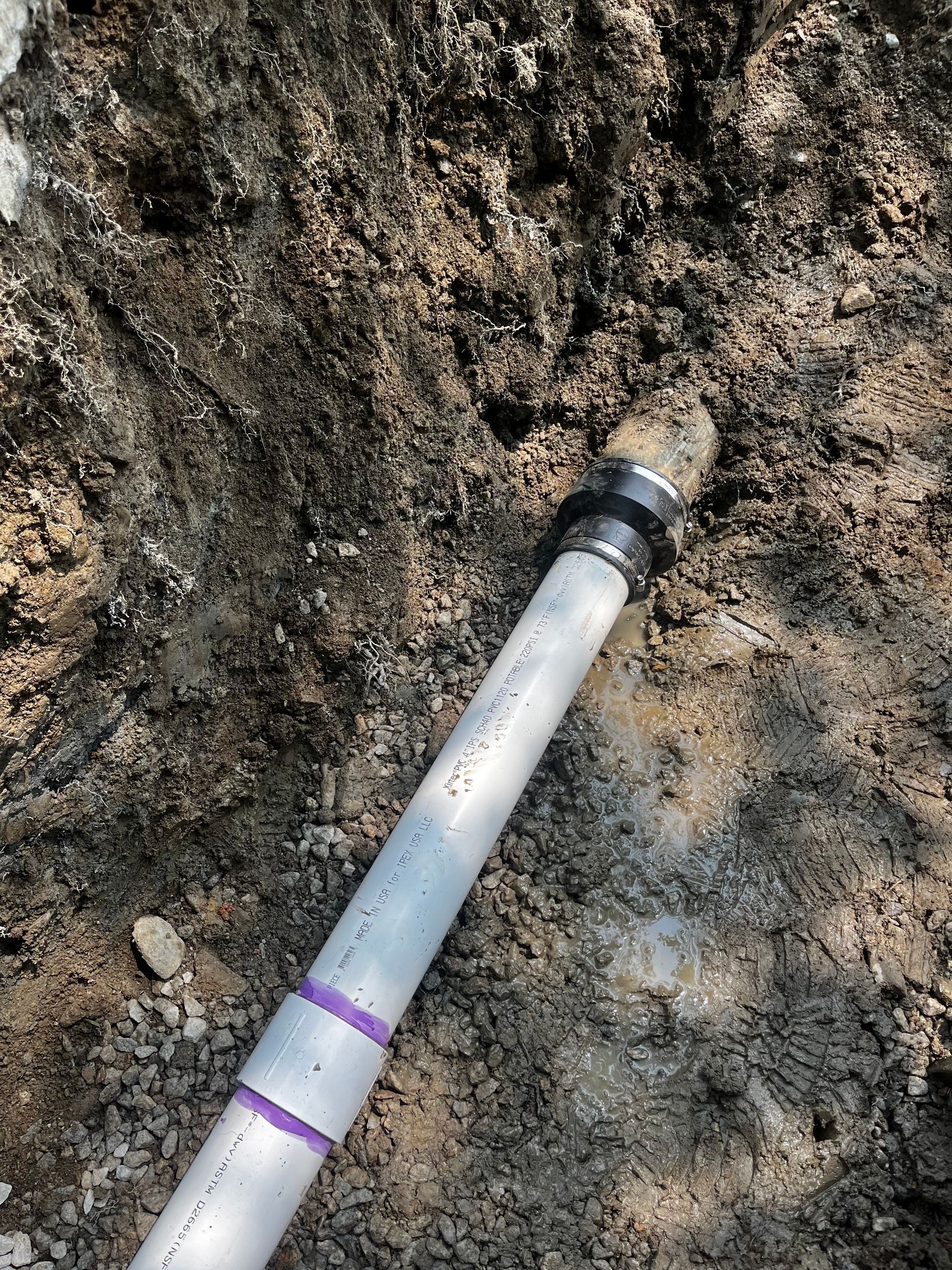 A pipe is laying in the dirt on the ground.