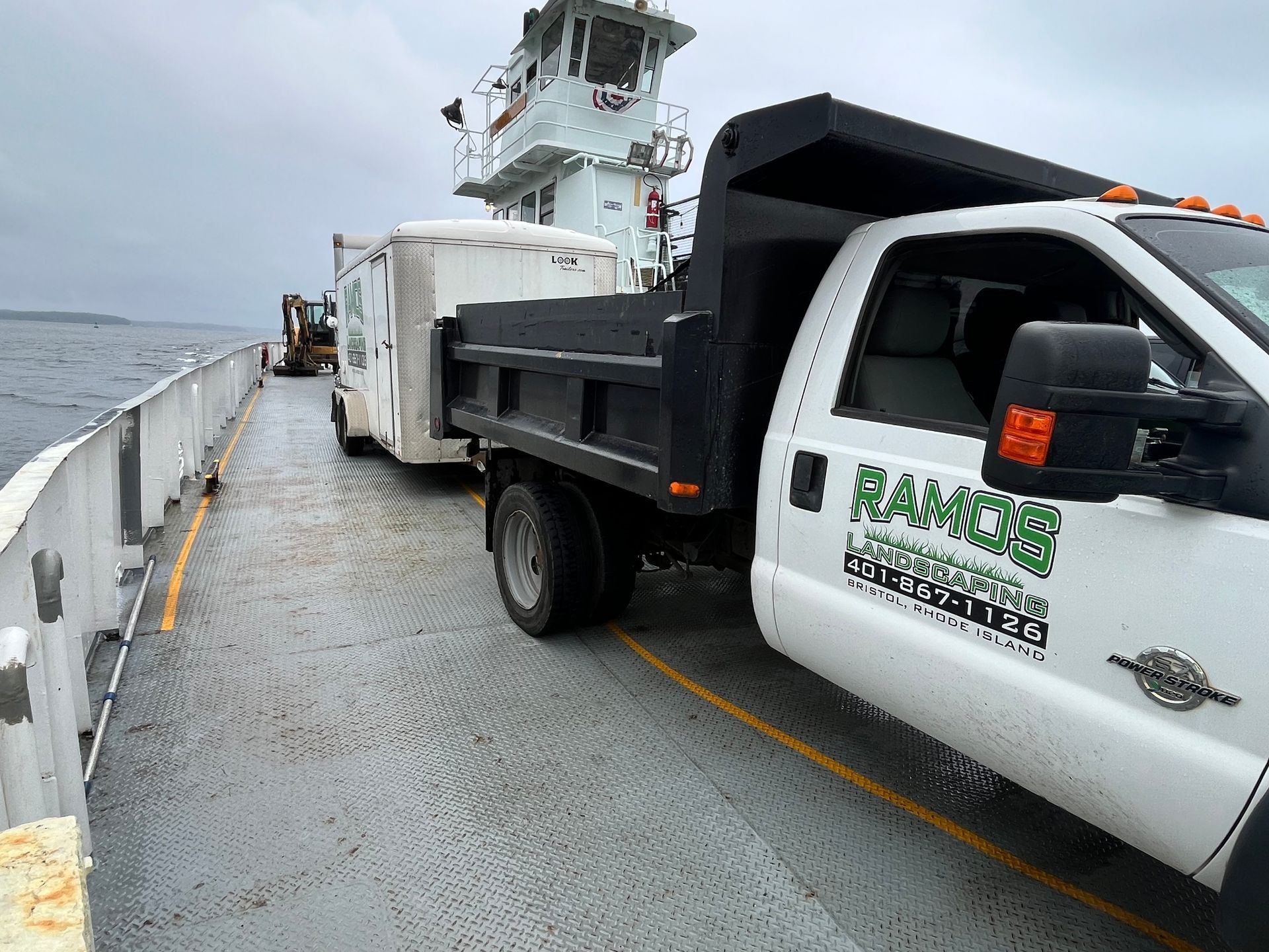 A dump truck is parked on the deck of a boat