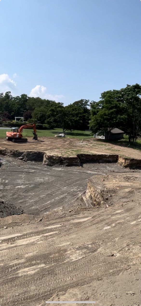A large excavator is digging a hole in a dirt field.