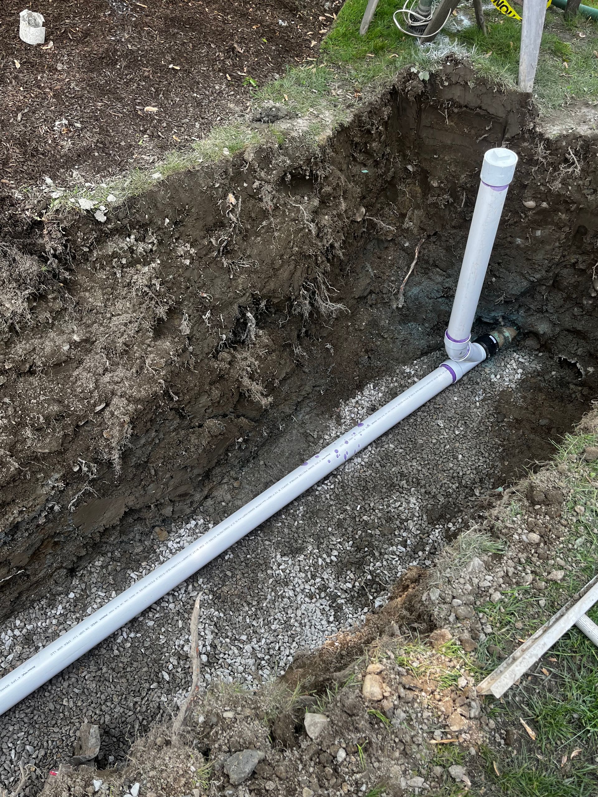 A pipe is being installed in a hole in the ground.