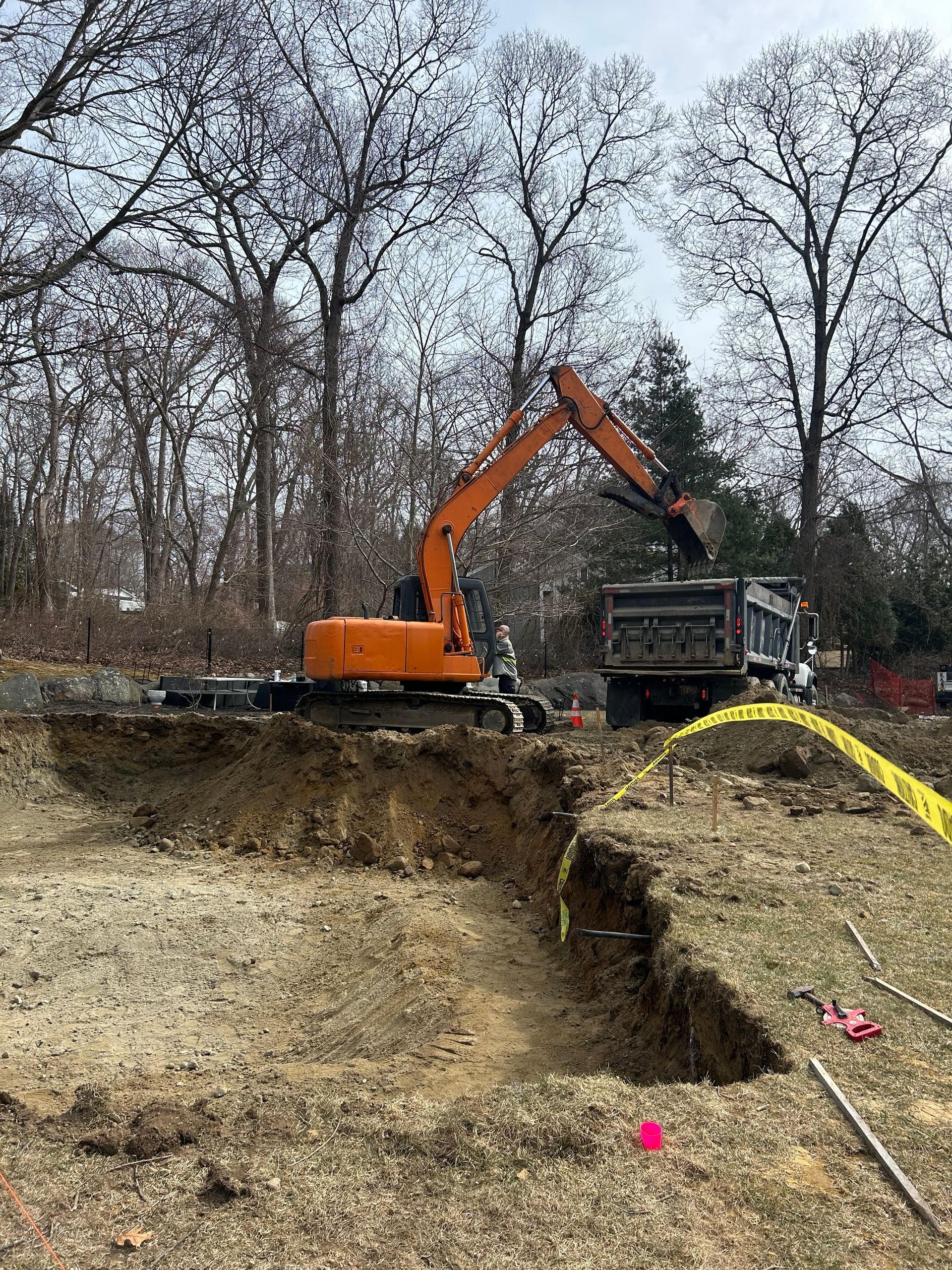 An excavator is digging a hole in the ground in a field.