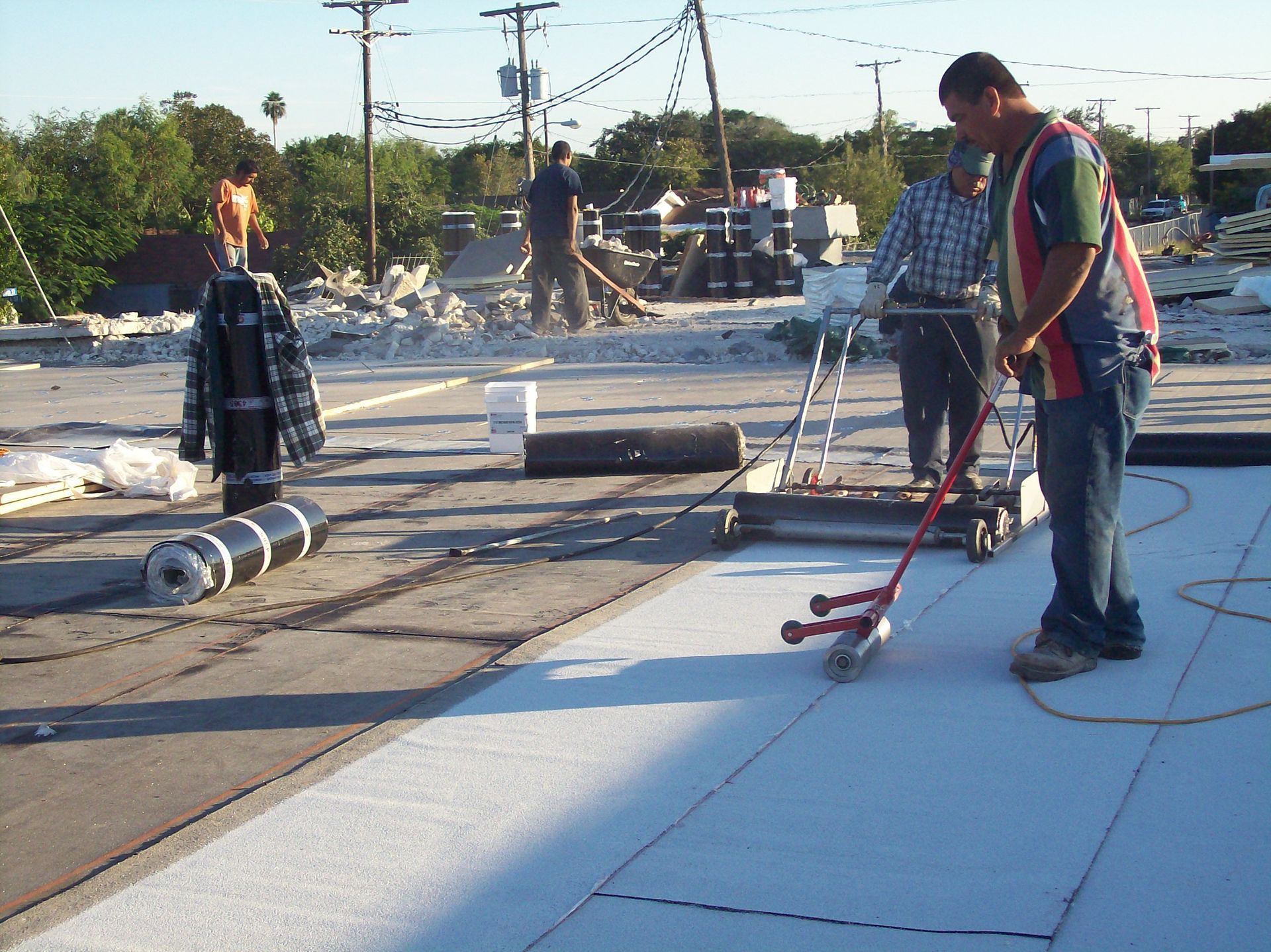 A group of construction workers are working on a roof