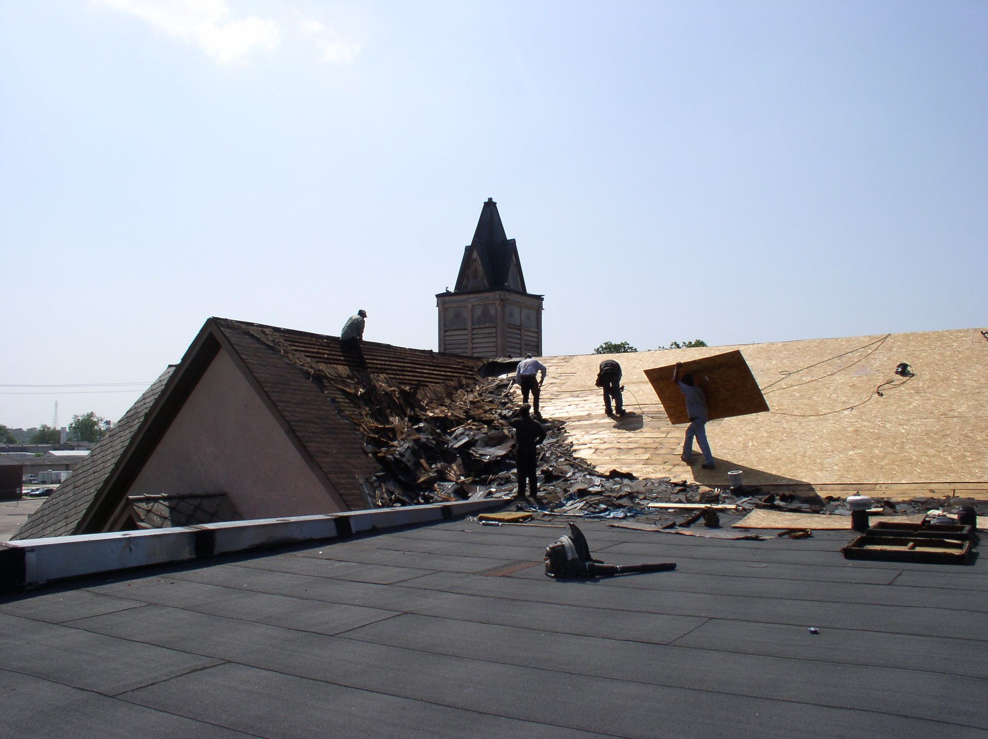 A group of people are working on the roof of a building
