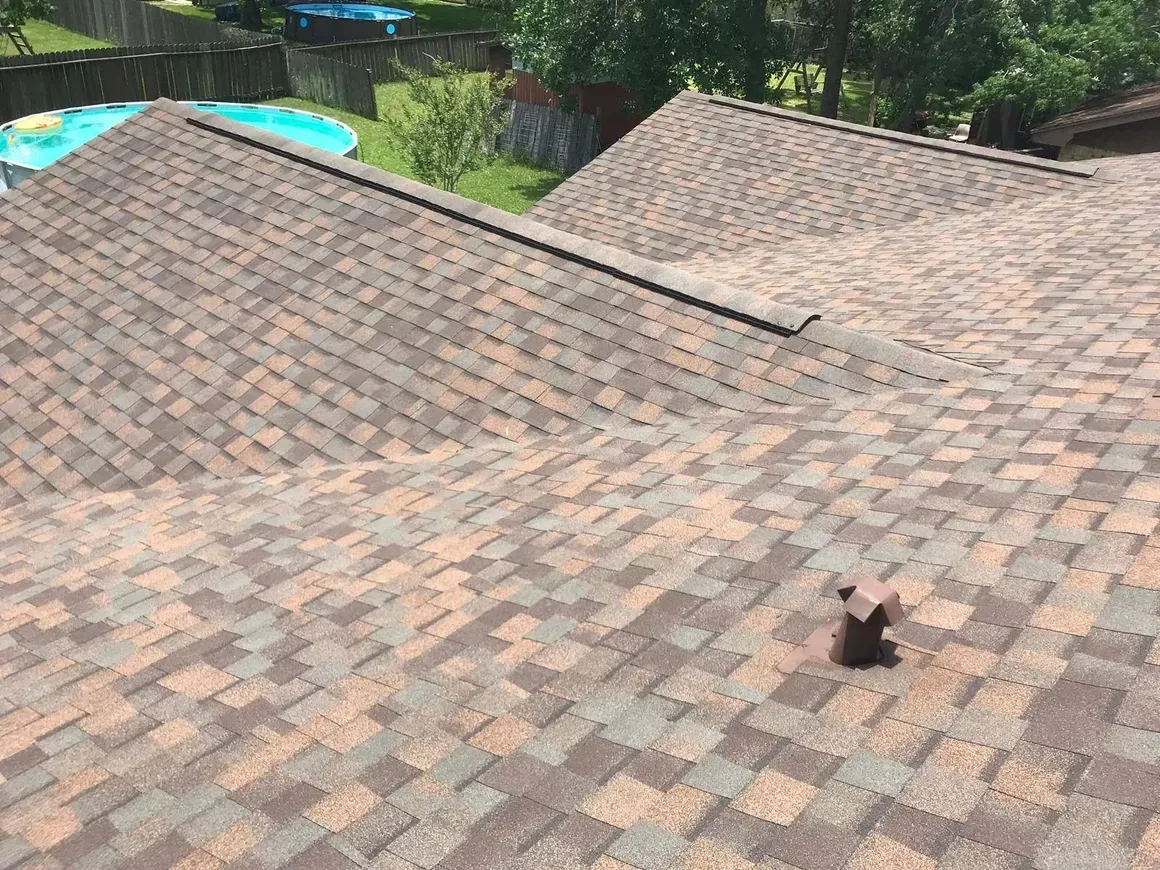 A roof with a hole in it and a pool in the background.