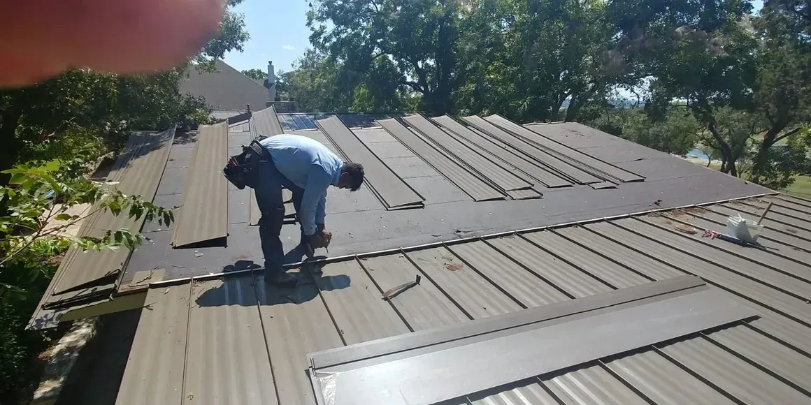 Two men are working on the roof of a house.