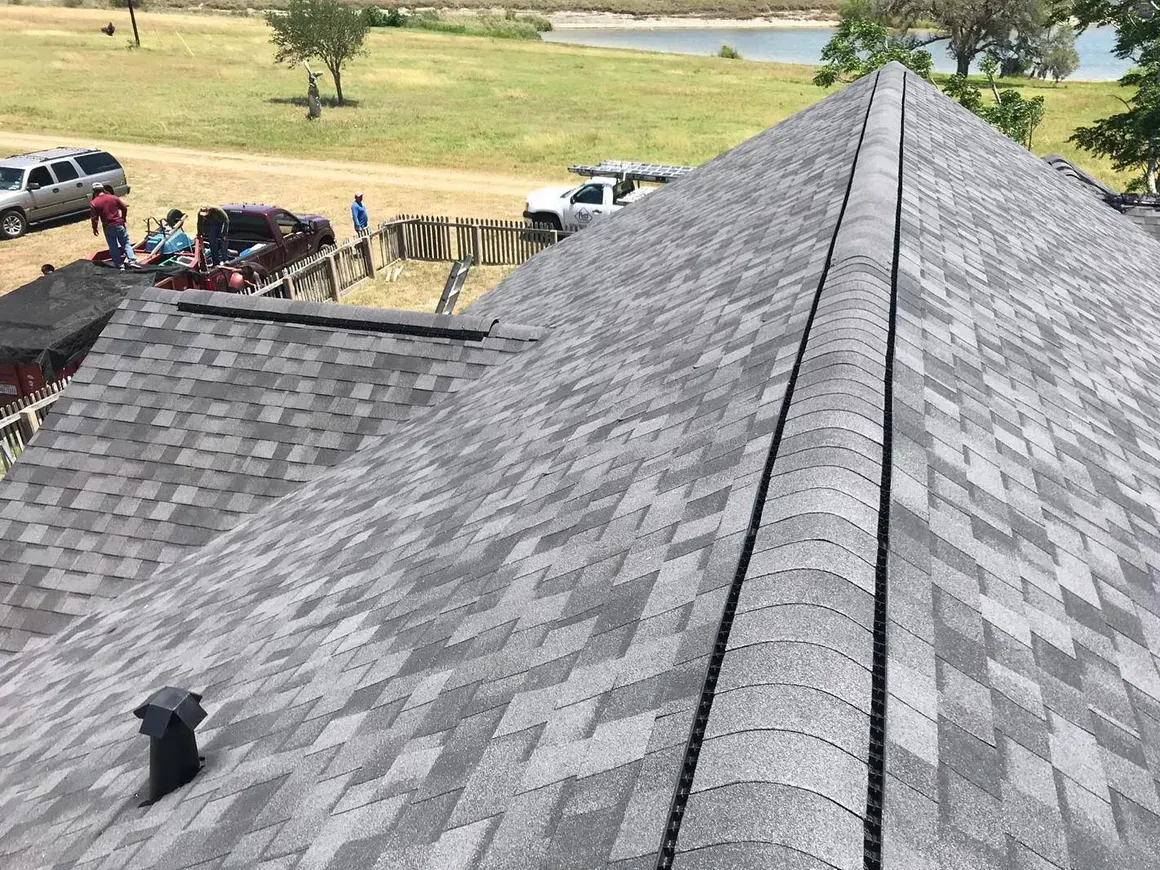 A group of people are working on the roof of a house.