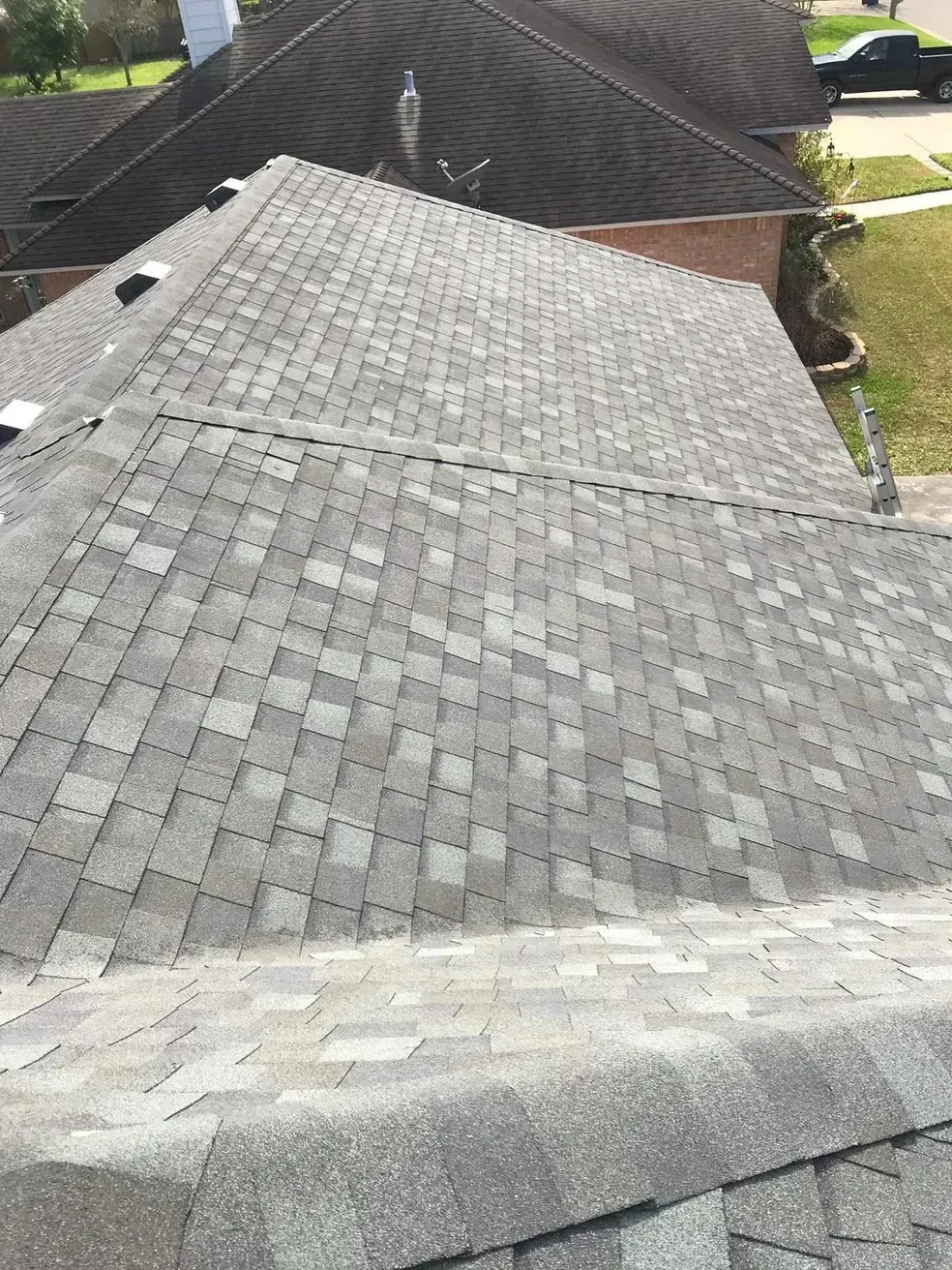 A close up of a roof with a truck parked in the background.