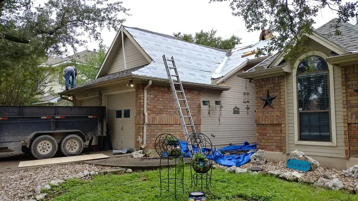 A man is working on the roof of a house.