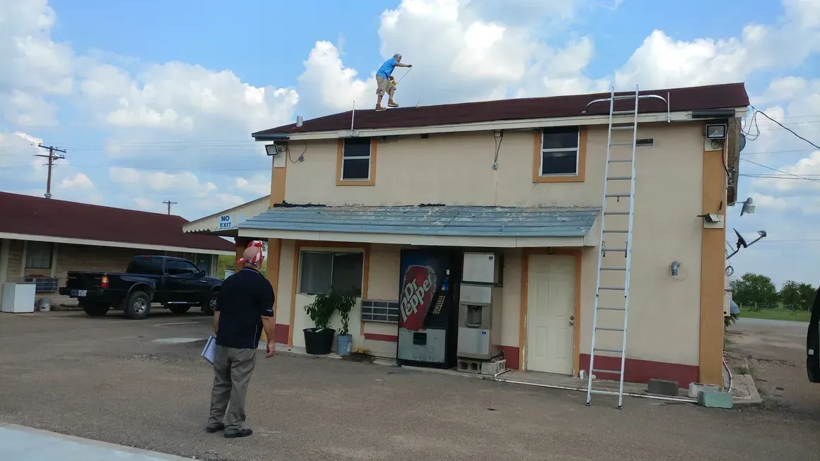 A man standing in front of a building with a coke machine