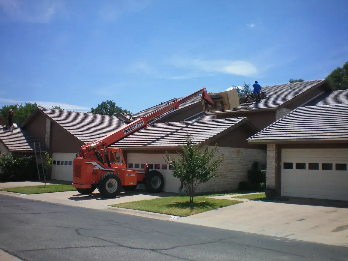 An orange tractor is parked in front of a row of houses