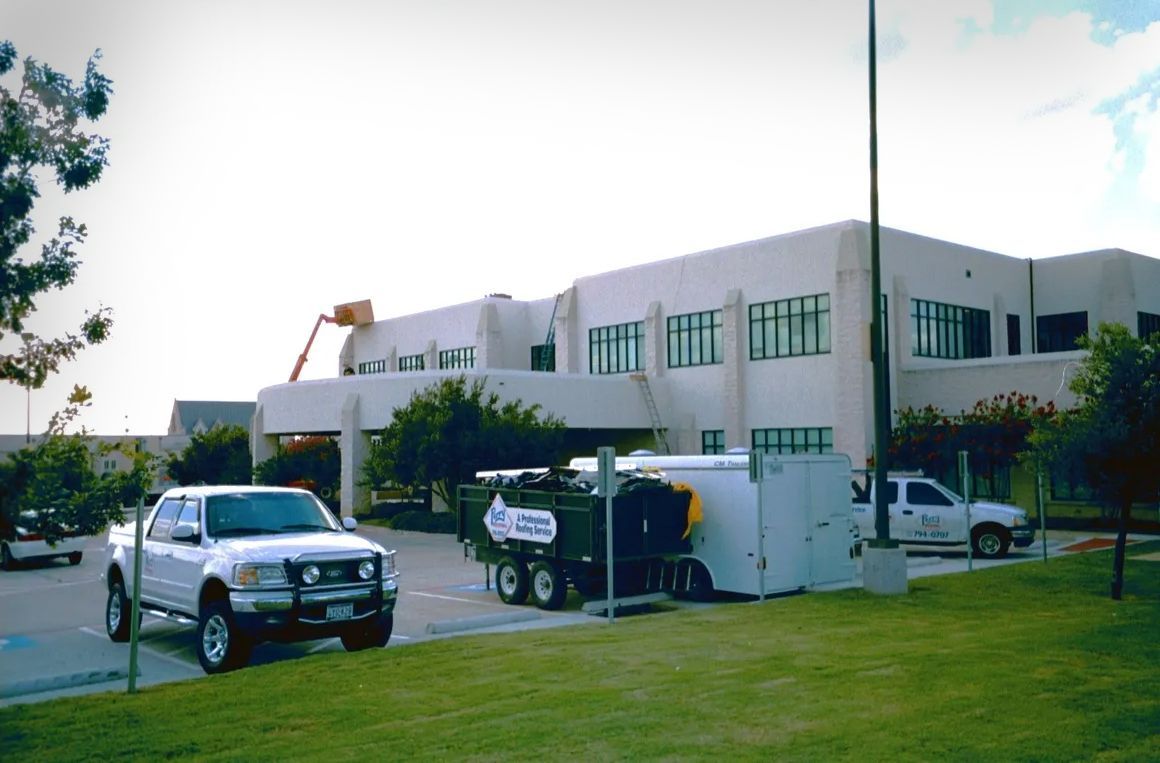 A white truck is parked in front of a large building