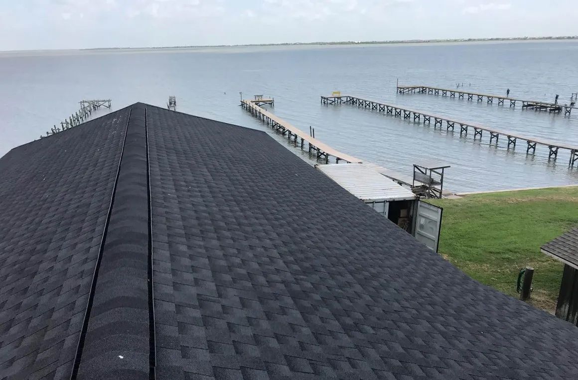 A black roof with a view of a body of water.
